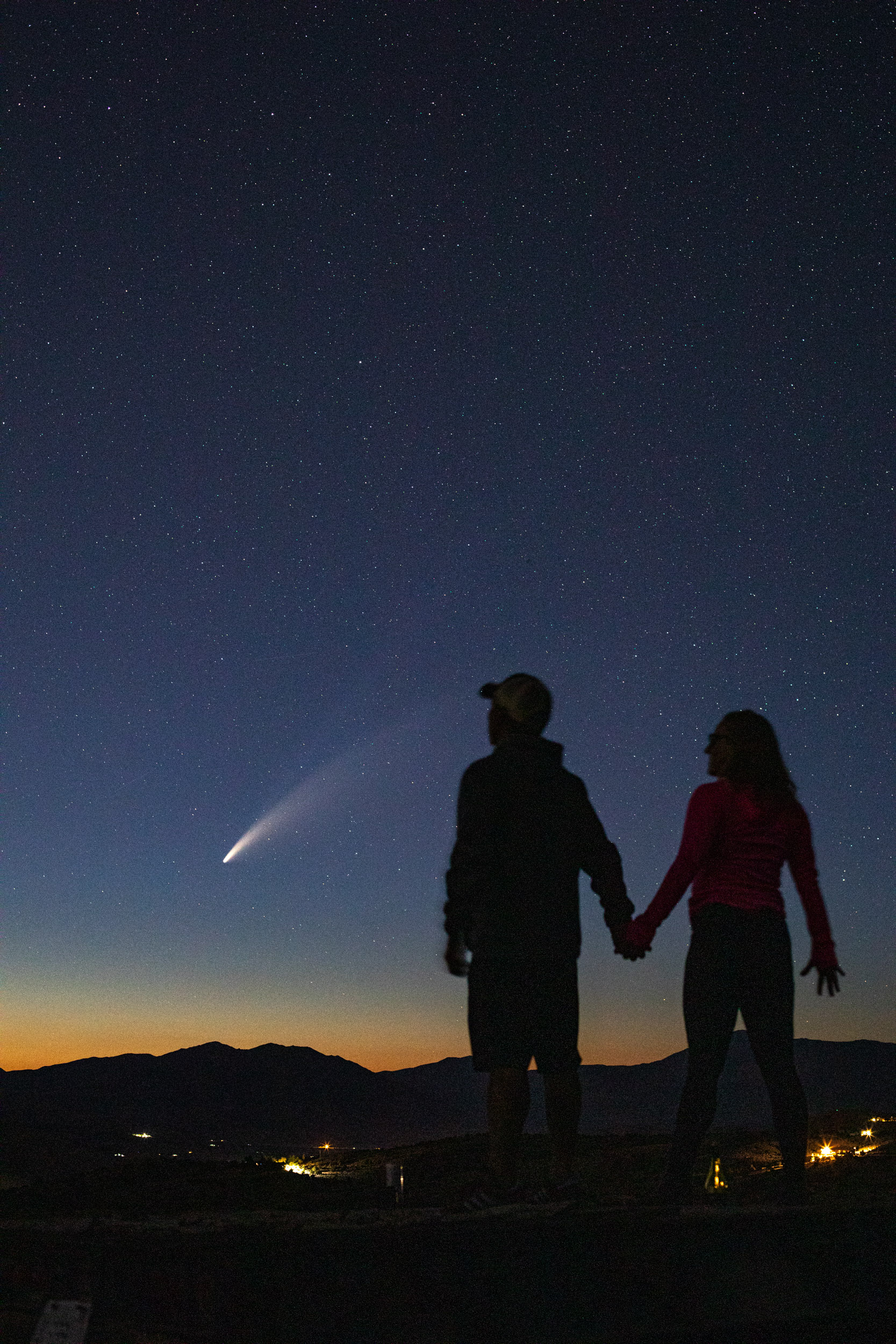 couple hold hands while viewing comet NeoWise