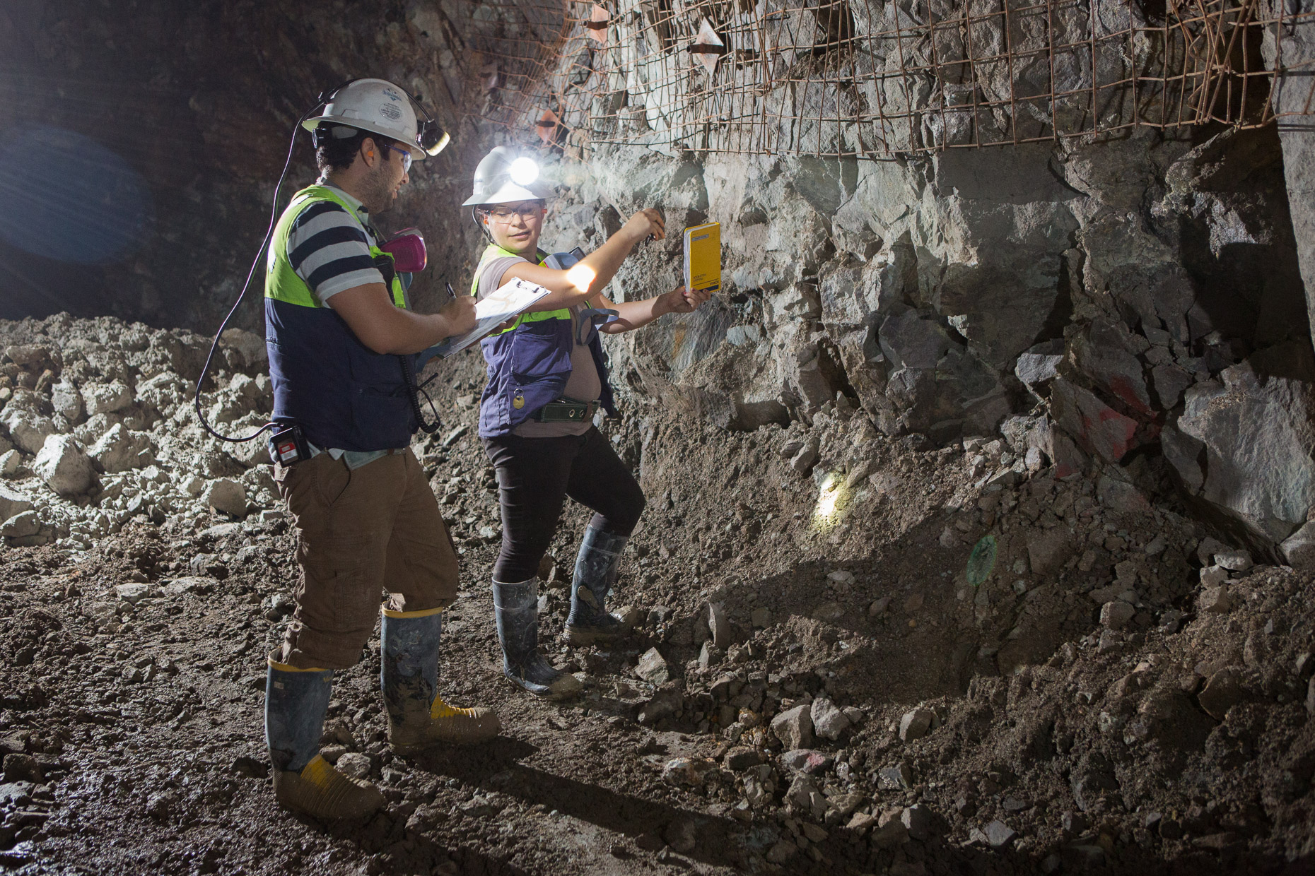 Geologist examine the wall of an underground mine