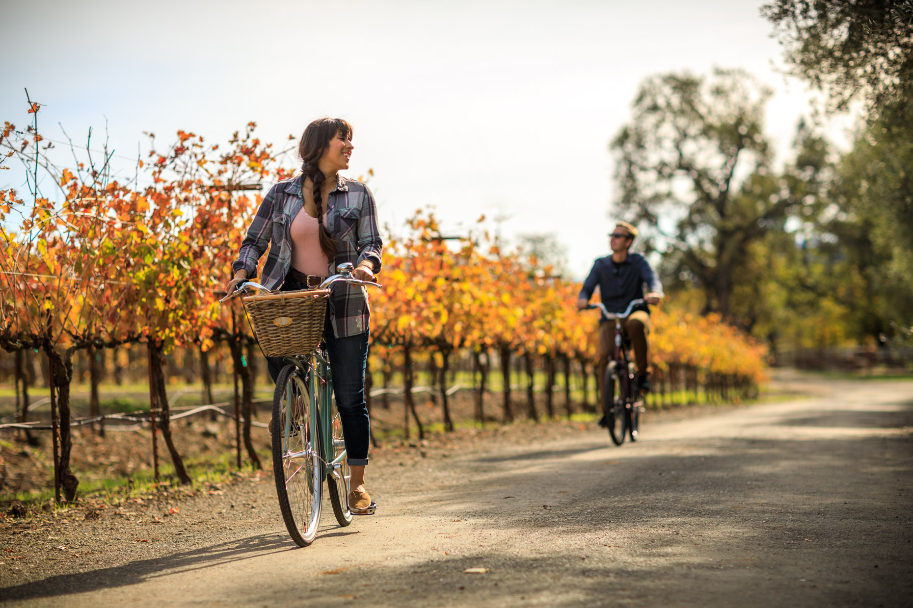 couple ride bikes through a vineyard in Napa