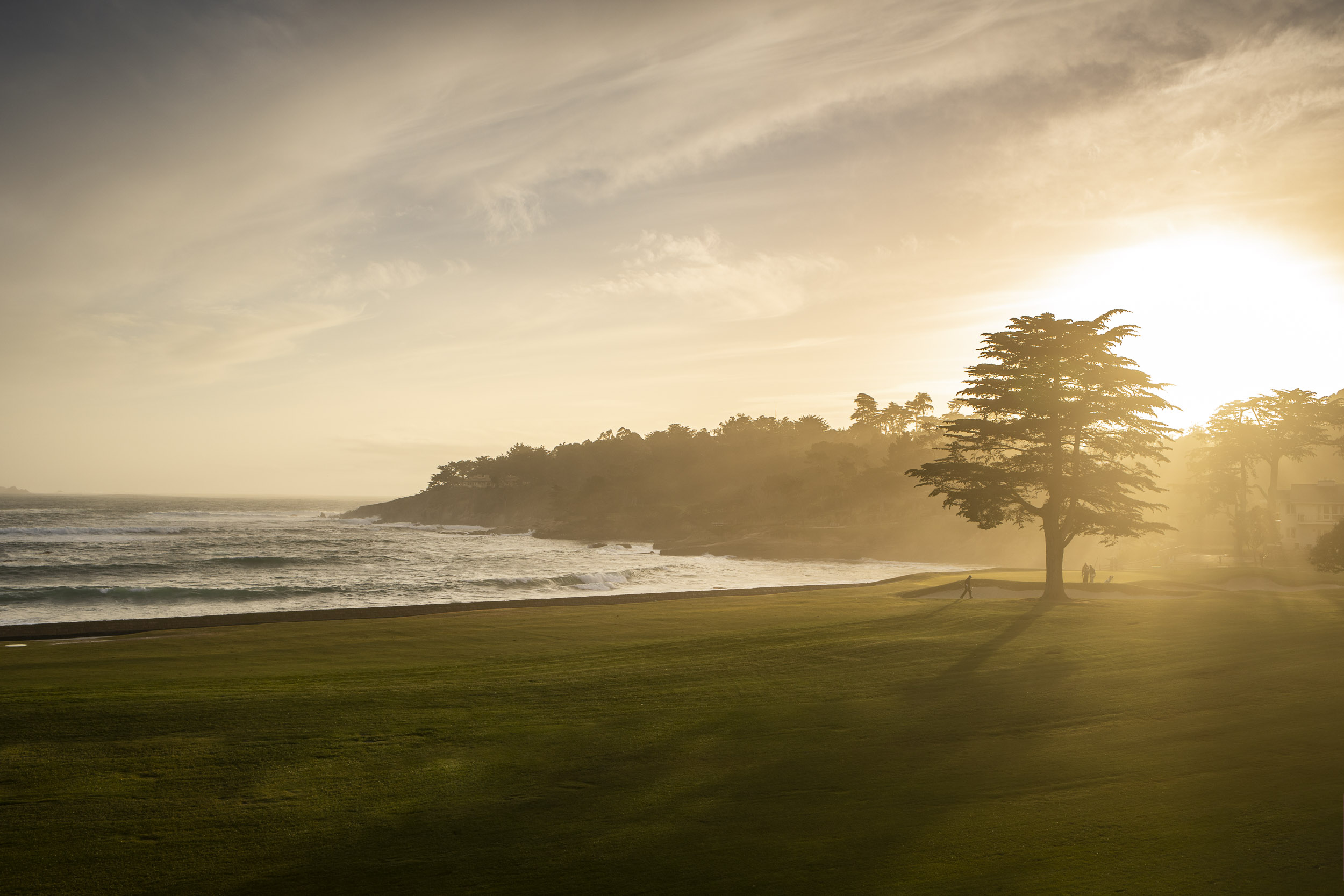 The sun sets over the icon 18th green at Pebble Beach.